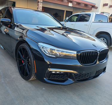 Black BMW 7 Series with a mirror-gloss finish outside the Norco shop