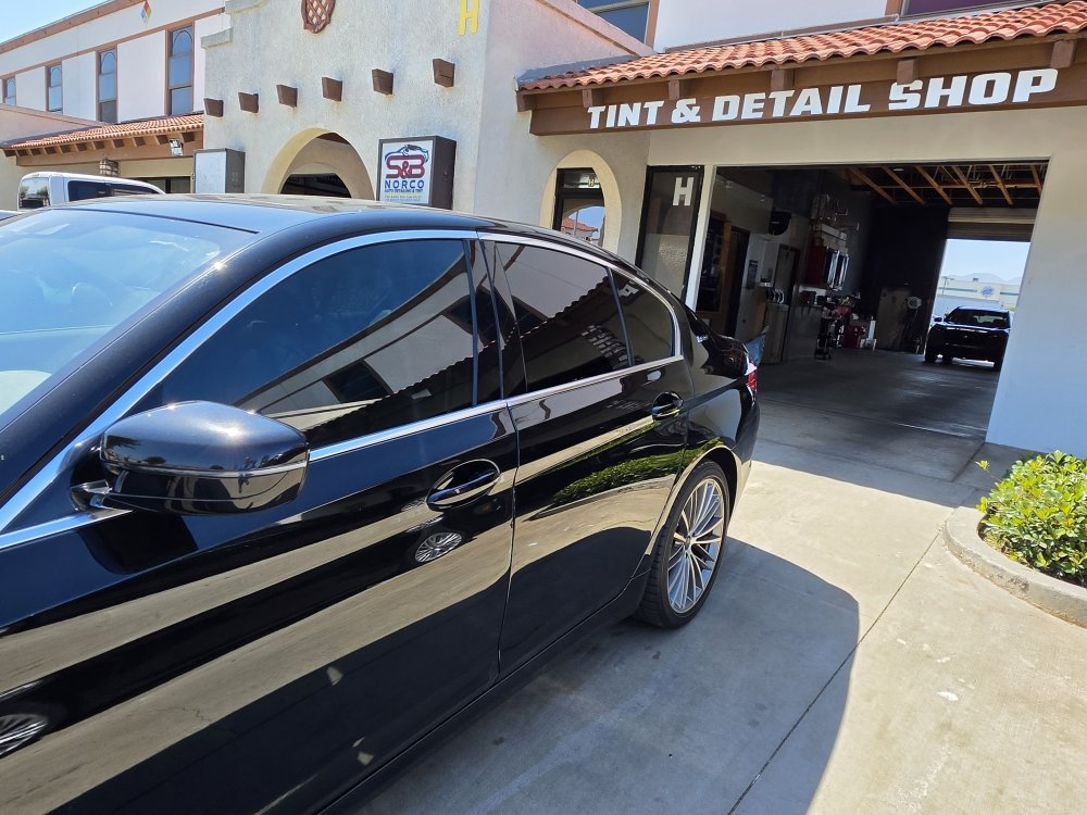 The Tint & Detail Shop storefront on Four Wheel Drive in Norco with a freshly tinted BMW out front