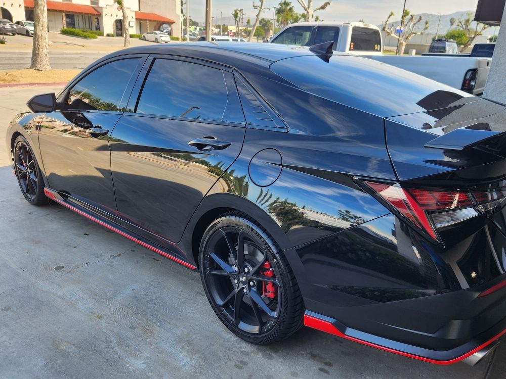 Black Hyundai Elantra N with red accents, tinted and glossed to a mirror finish