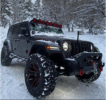 Black Jeep Wrangler with light bar in fresh snow