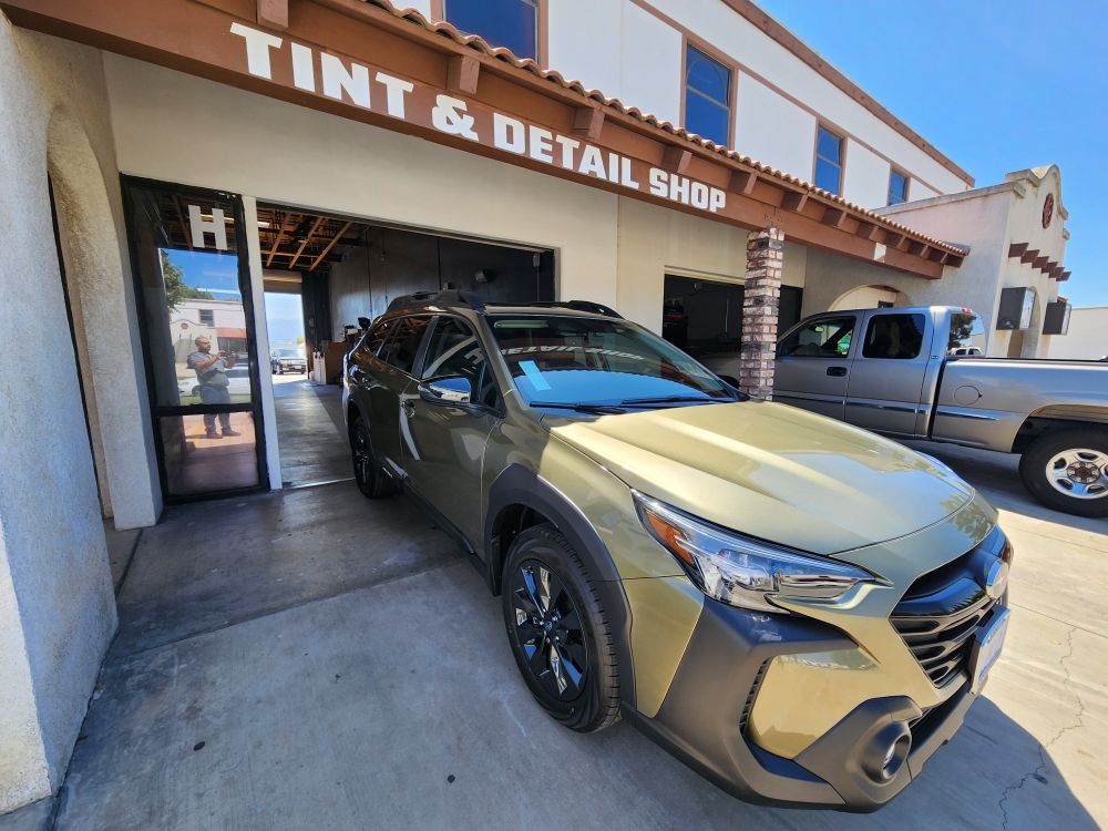 Vehicles in front of the Tint & Detail Shop bays