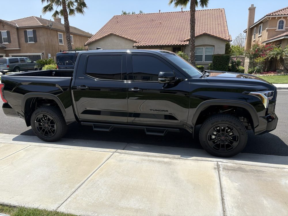Black Toyota Tundra with full window tint, side profile